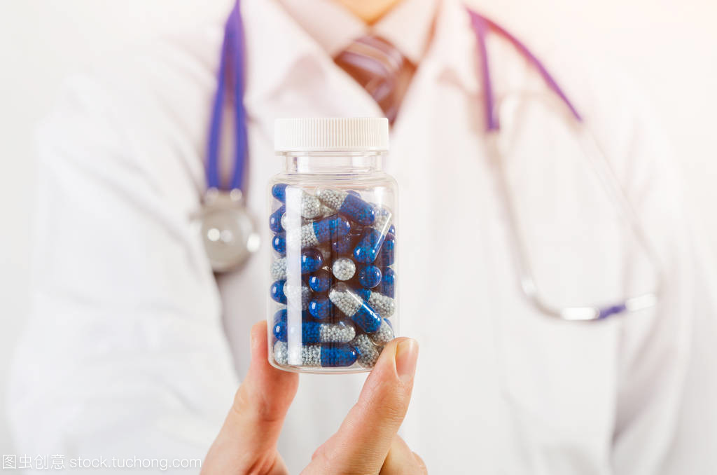 医生科学家发明新的药物,持有胶囊在手中